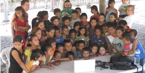 The kids of El Tamarindo crowd around a laptop computer