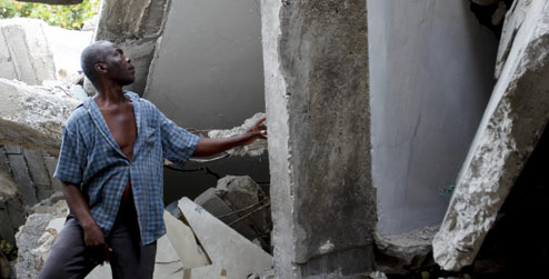 Wibert Joseph stands in the empty shell where his house used to be before the 2010 Haiti earthquake