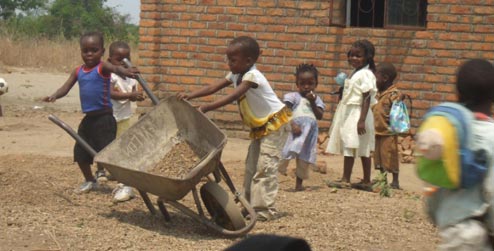 Children playing with a wheelbarrow