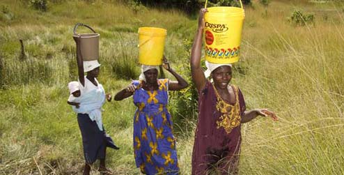 3 Zimbawean women carrying water on their heads