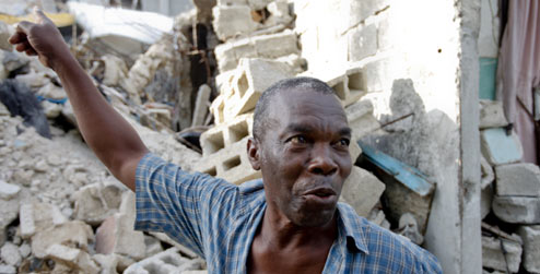 Wilbert Joseph pointing at the ruins of his house
