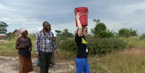 Pamela carrying bucket of water