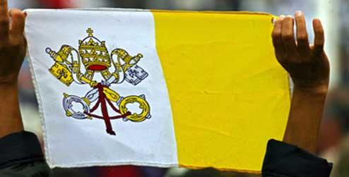 A Vatican flag is held aloft