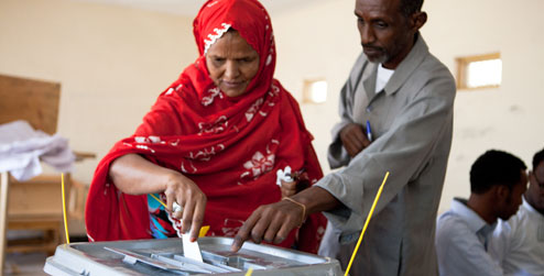 Woman puts voting slip in box at polling station in Somaliland