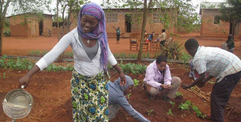 ICS volunteer, Nneka Cummins gardening with locals in Malawi