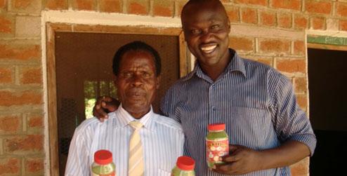 Innocent Ogaba and Mr Laston holding moringa jars