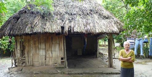 Mélida Tróchez standing by her house, which she has rebuilt four times.
