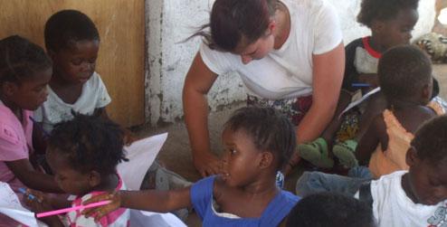 ICS volunteer Sammy drawing with children at community centre