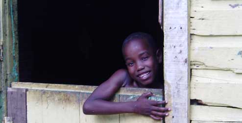 A child looks through a doorway in the Dominican Republic