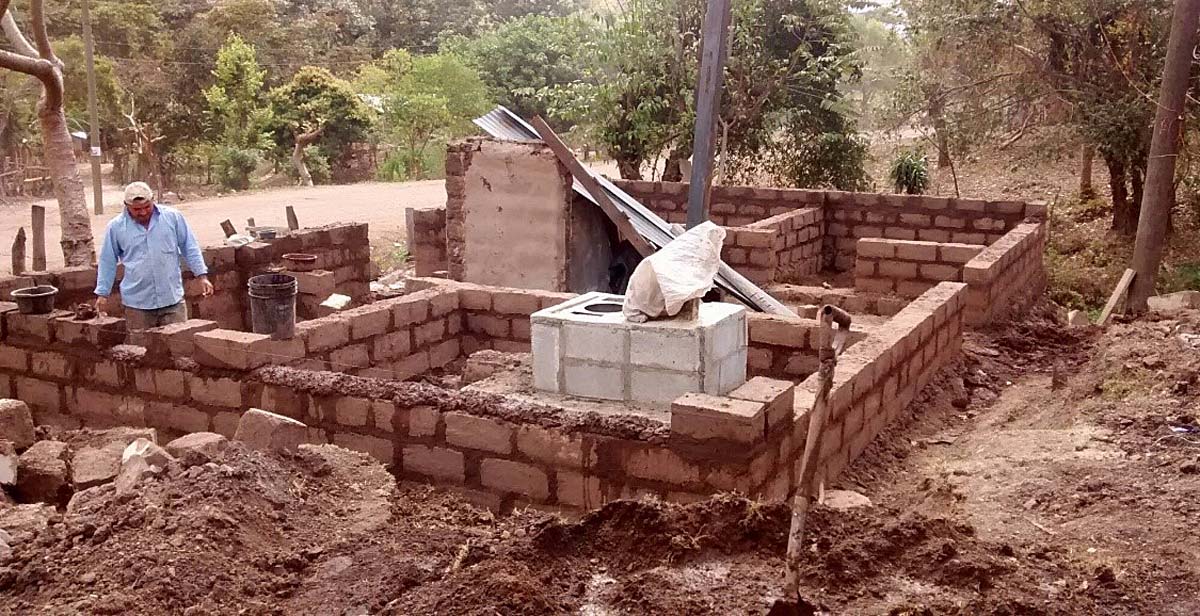 A house being made from mud (adobe) bricks around the new eco-stove we built