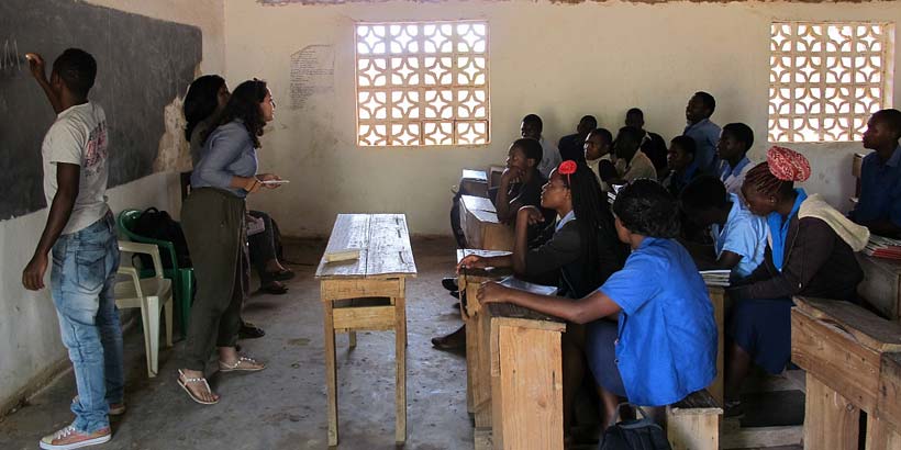 Ikram facilitating a peer education session at Masasa secondary school, with help from Nelson and Lennie