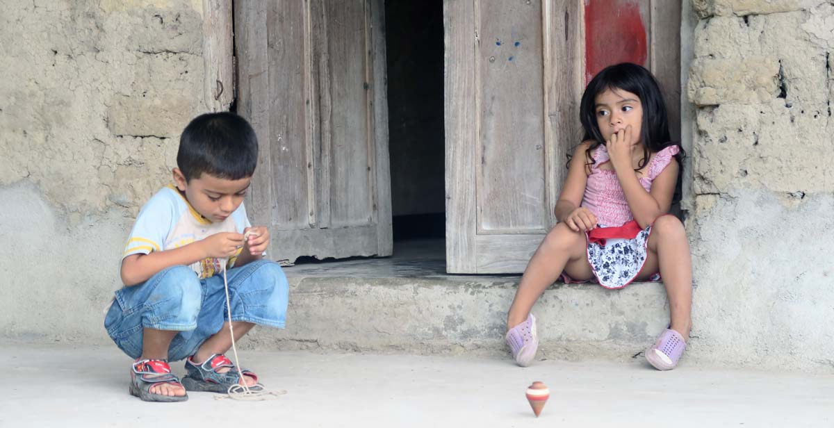 A young girl and boy playing in the street