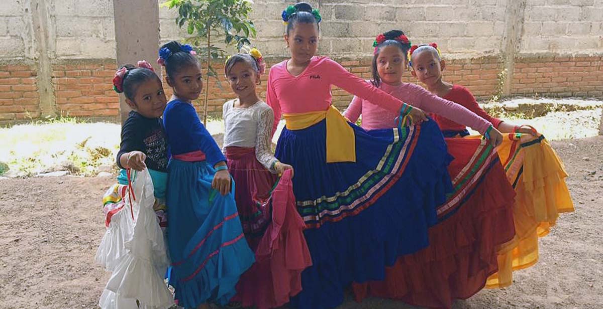 Pupils dressed in traditional Honduran dresses getting ready to go on stage