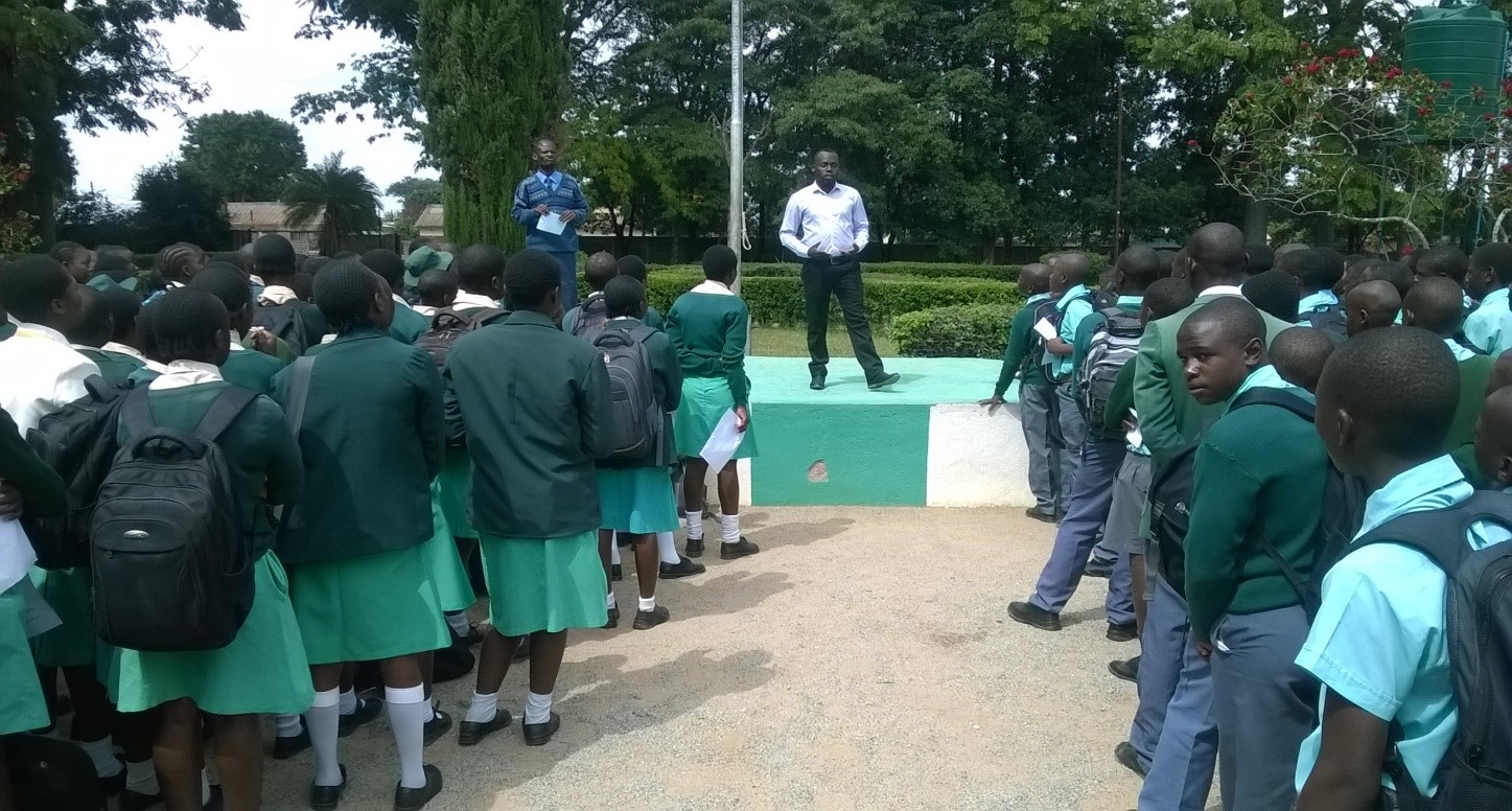 A man presents to a large crowd of school pupils