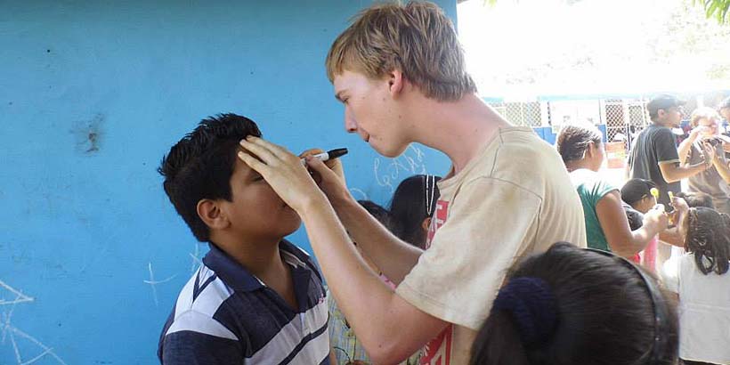 Matt engaging in face painting in a local school