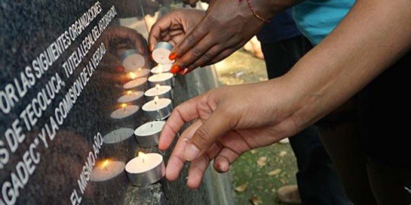 ICS volunteers lighting candles at the memorial