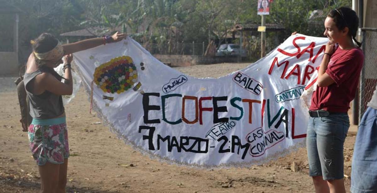 Elza and Giulia show the banner that the Eco-festival Promotion Group proudly created using cloth and other recycled materials