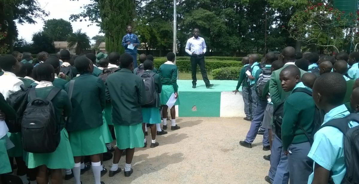 A man presents to a large crowd of school pupils