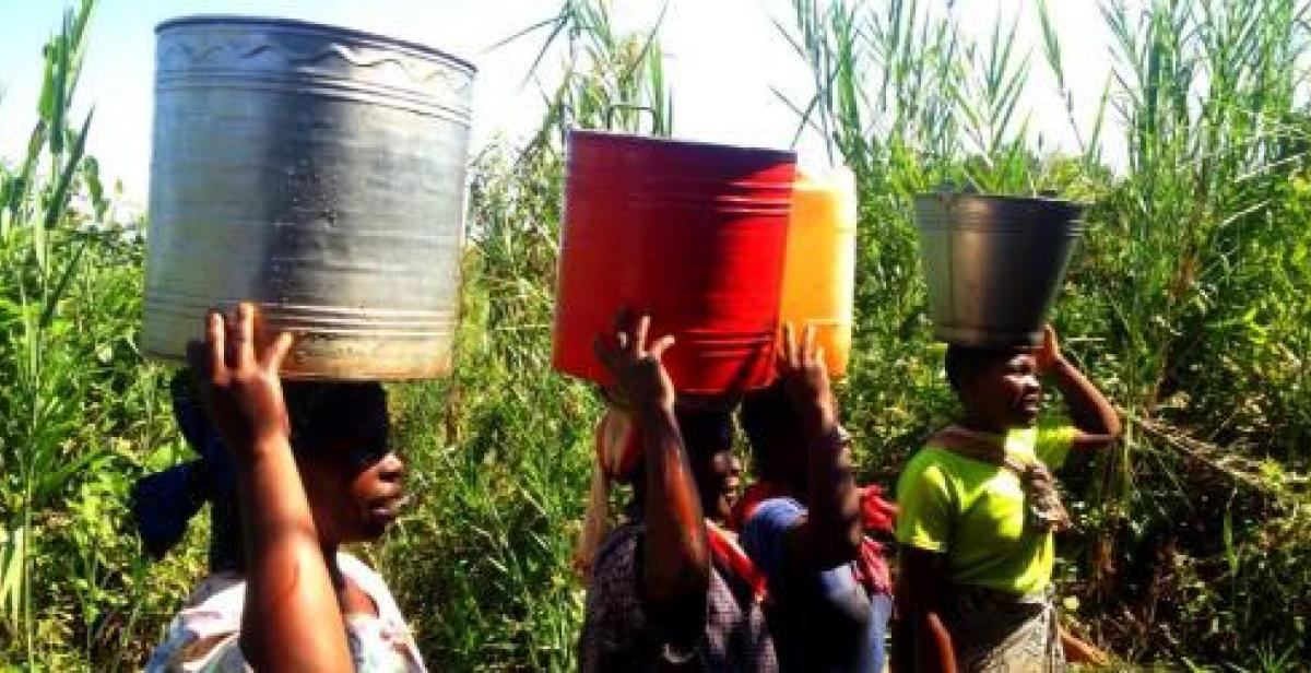 Women in Malawi carrying buckets on their heads