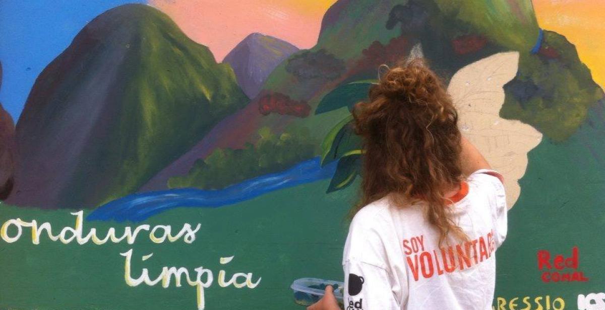 Volunteer painting a mural 