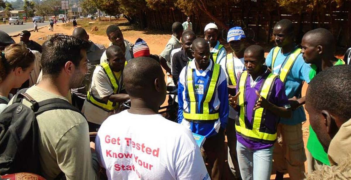 Nowras, Emily and George conducting a peer education session educating bicycle taxi operators about HIV and AIDS, STI’s, HTC and positive living