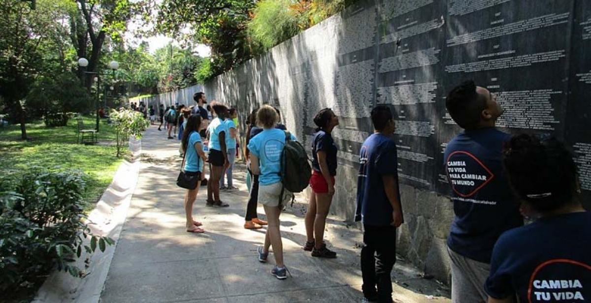 ICS volunteers reading the names of the killed and missing on the memorial plaque in Parque Cuscatlán