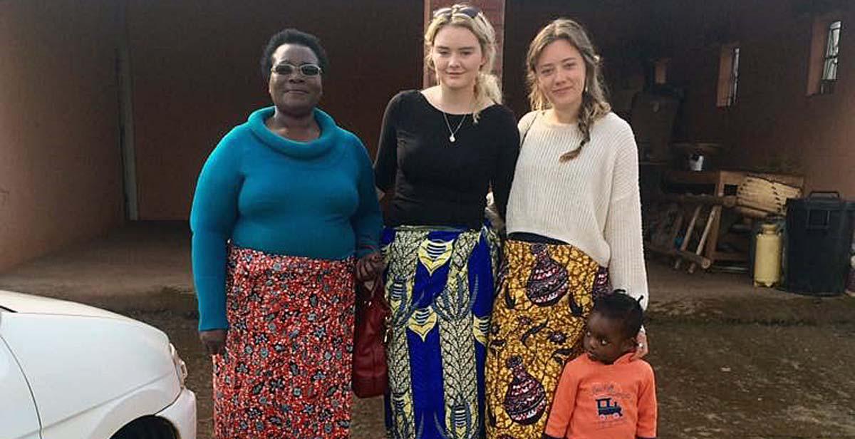 Jessica and Niamh wearing chitenjes with their host mum and host niece