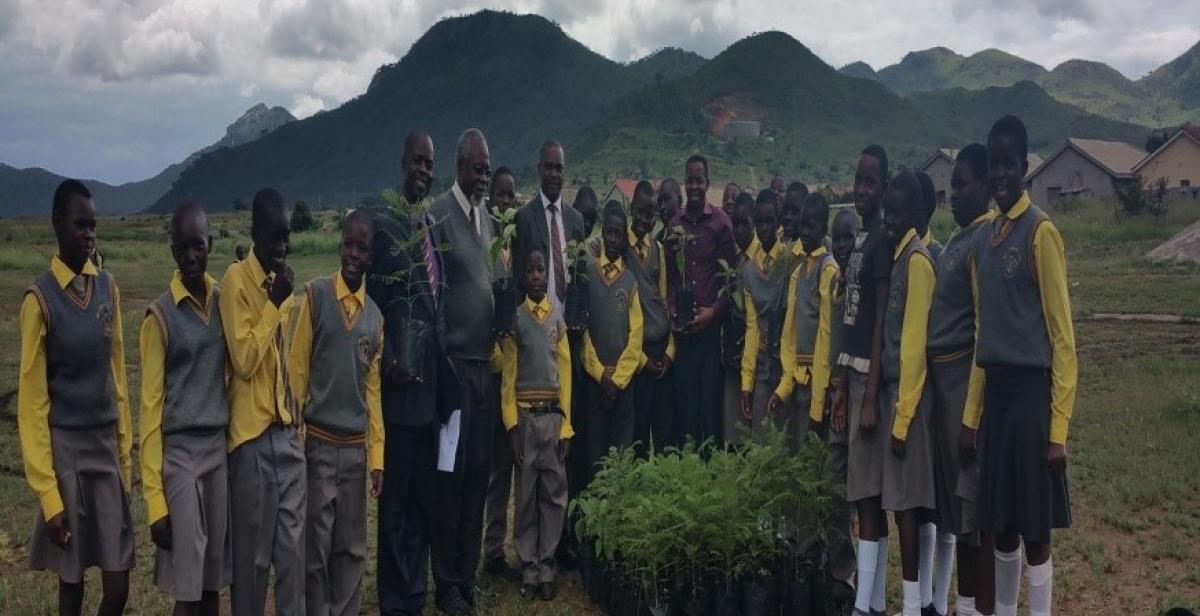 Teachers and School Children stand in front of donated trees