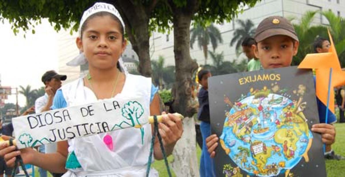 Young participants holding banners at Earth Day march in El Salvador