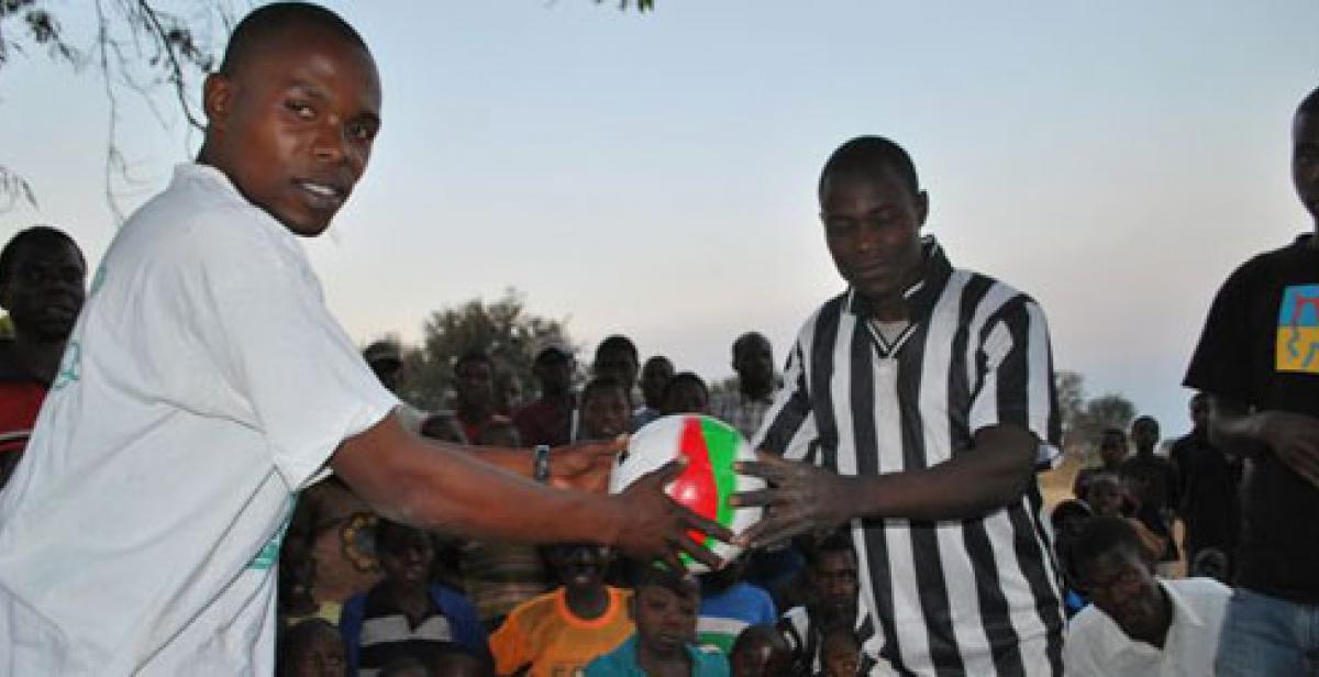 Two men holding a football in Malawi