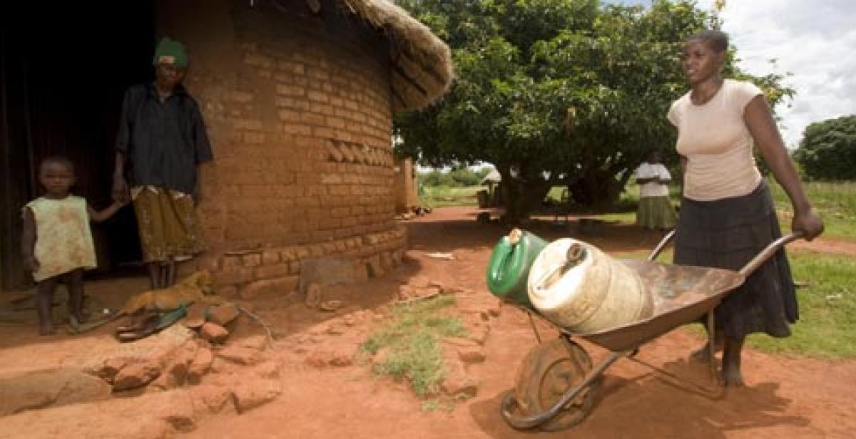 Jane Mudiiwa carries water from a local well, Zimbabwe, Macpherson photographers