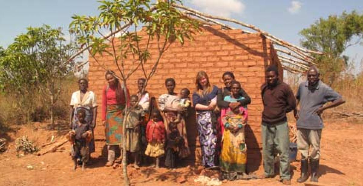 Rose Kumwenda (third right) and family in front of her newly built house constru