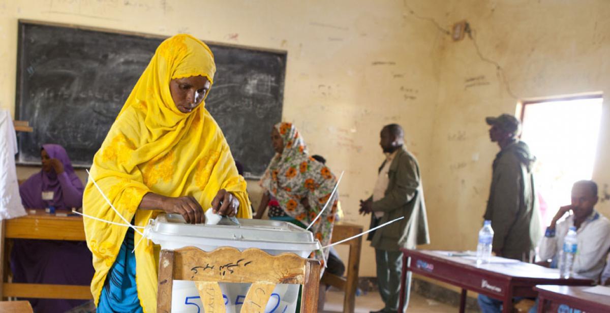 Woman places vote in ballot box, Somaliland