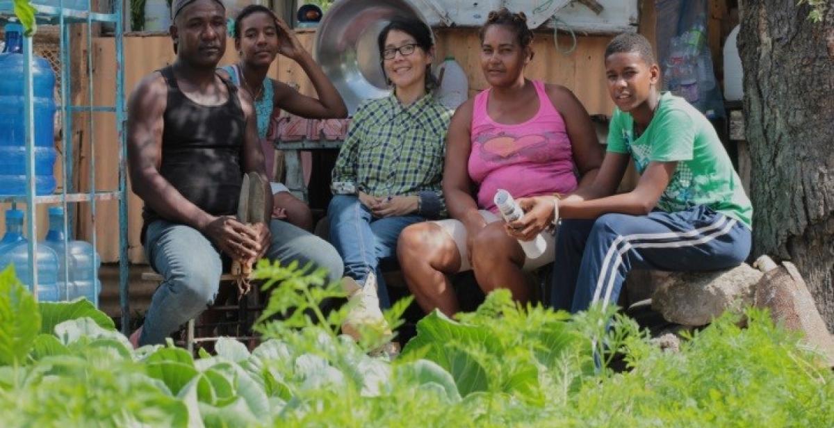 The Fleming family and Progressio Development Worker, Nadie, sitting in their vegetable garden