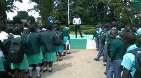 A man presents to a large crowd of school pupils