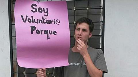 Jolyon holding a banner he made for International Volunteer Day 2014