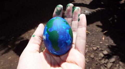  Egg painted like world in a hand