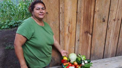 Gladys with her veg grown from seeds given by ASOMUPRO