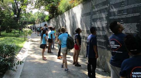 ICS volunteers reading the names of the killed and missing on the memorial plaque in Parque Cuscatlán