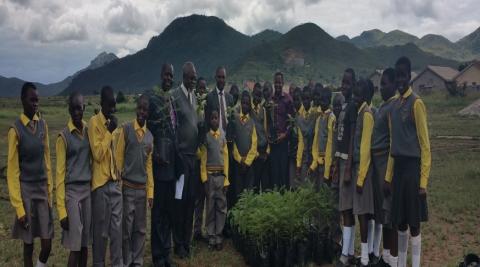 Teachers and School Children stand in front of donated trees