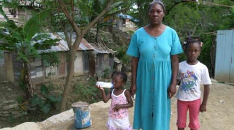 A woman and her children in front of a house in Santiago, Dominican Republic