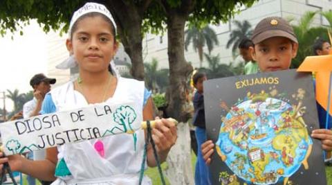 Young participants holding banners at Earth Day march in El Salvador