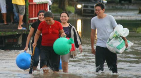 People wading through flood water in San Francisco Menendez, El Salvador