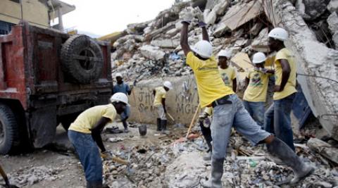 Haitians pile rubble into a waiting van