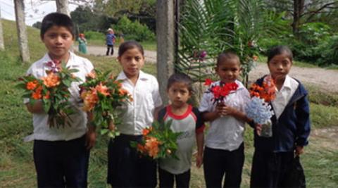 Children welcoming visitors with floweres