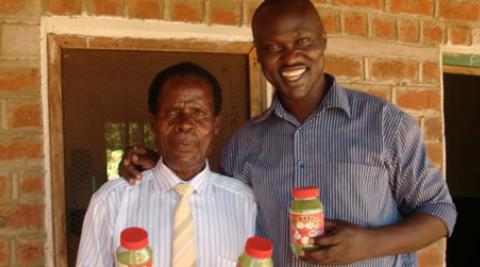 Innocent Ogaba and Mr Laston holding moringa jars