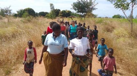 Women walking through a field in Malawi