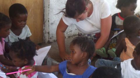 ICS volunteer Sammy drawing with children at community centre