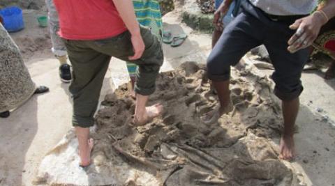 People kicking clay with their feet, Malawi