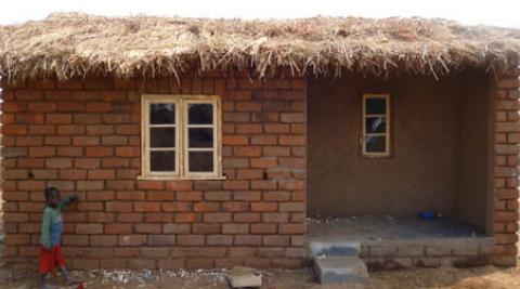 Thoko beside his house